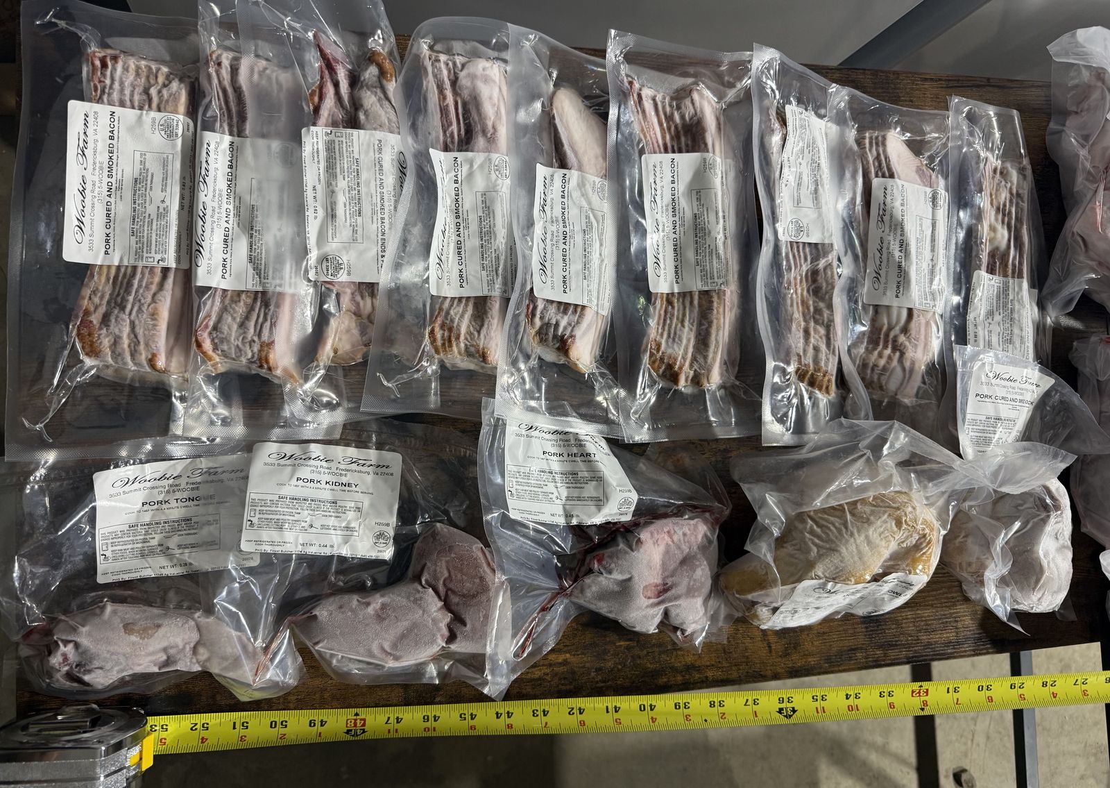 Trays of cured and smoked bacon, vacuum-sealed and labeled by Woobie Farm, ready for pickup